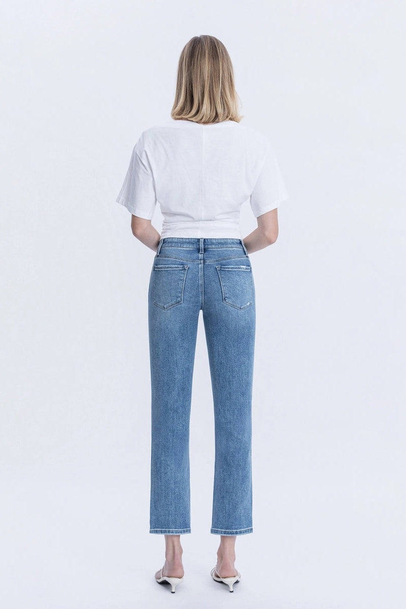 Person wearing blue jeans and a white t-shirt on a light gray background