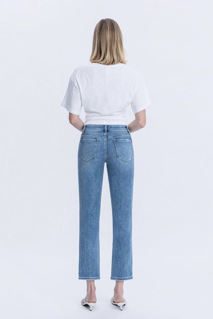 Person wearing blue jeans and a white t-shirt on a light gray background
