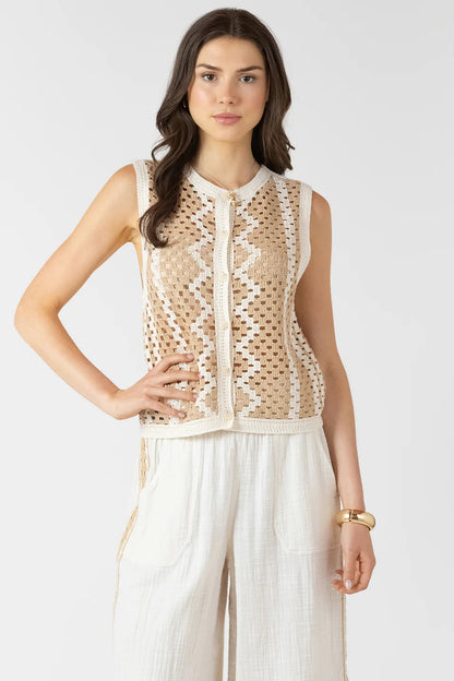 Woman wearing a beige lace top and white pants on a white background