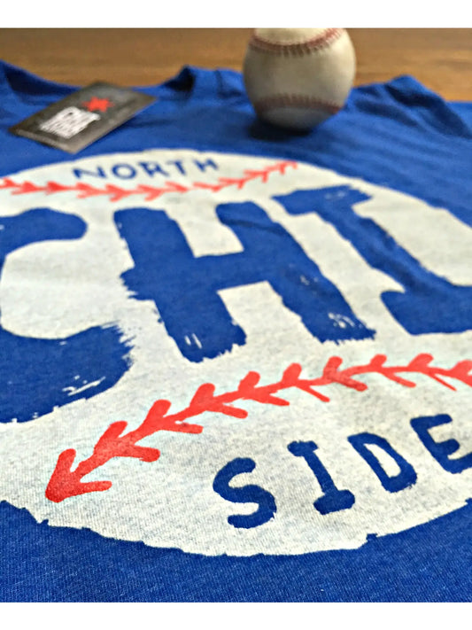 Blue t-shirt with 'North Side Chicago' print and a baseball on a wooden surface