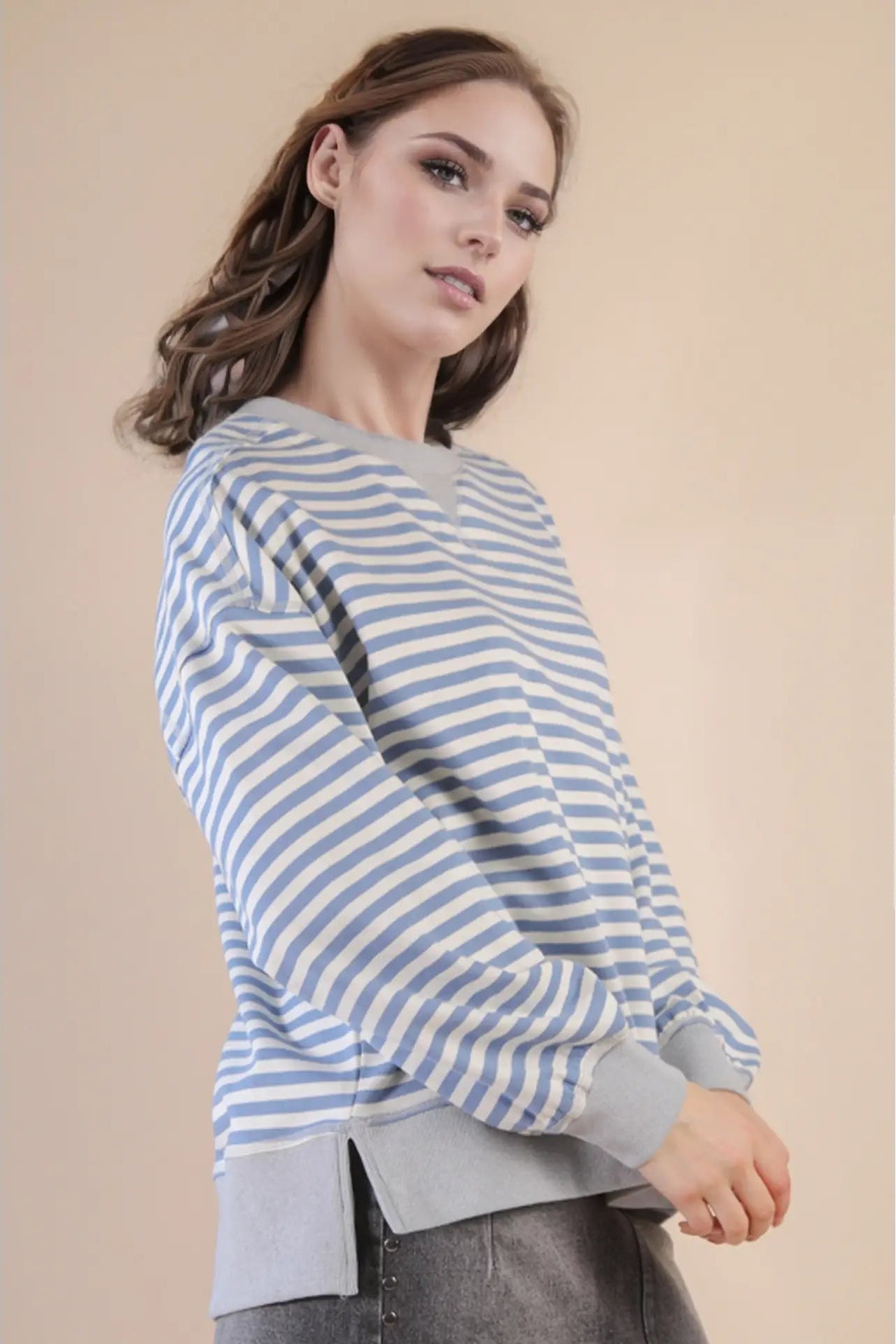 Woman wearing a blue and white striped sweater against a beige background