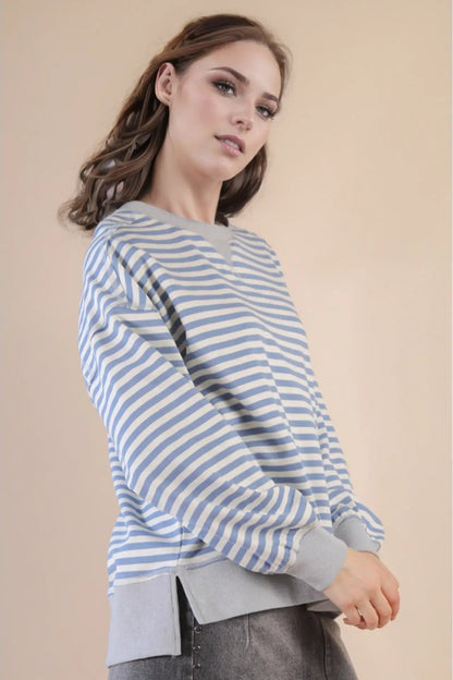 Woman wearing a blue and white striped sweater against a beige background