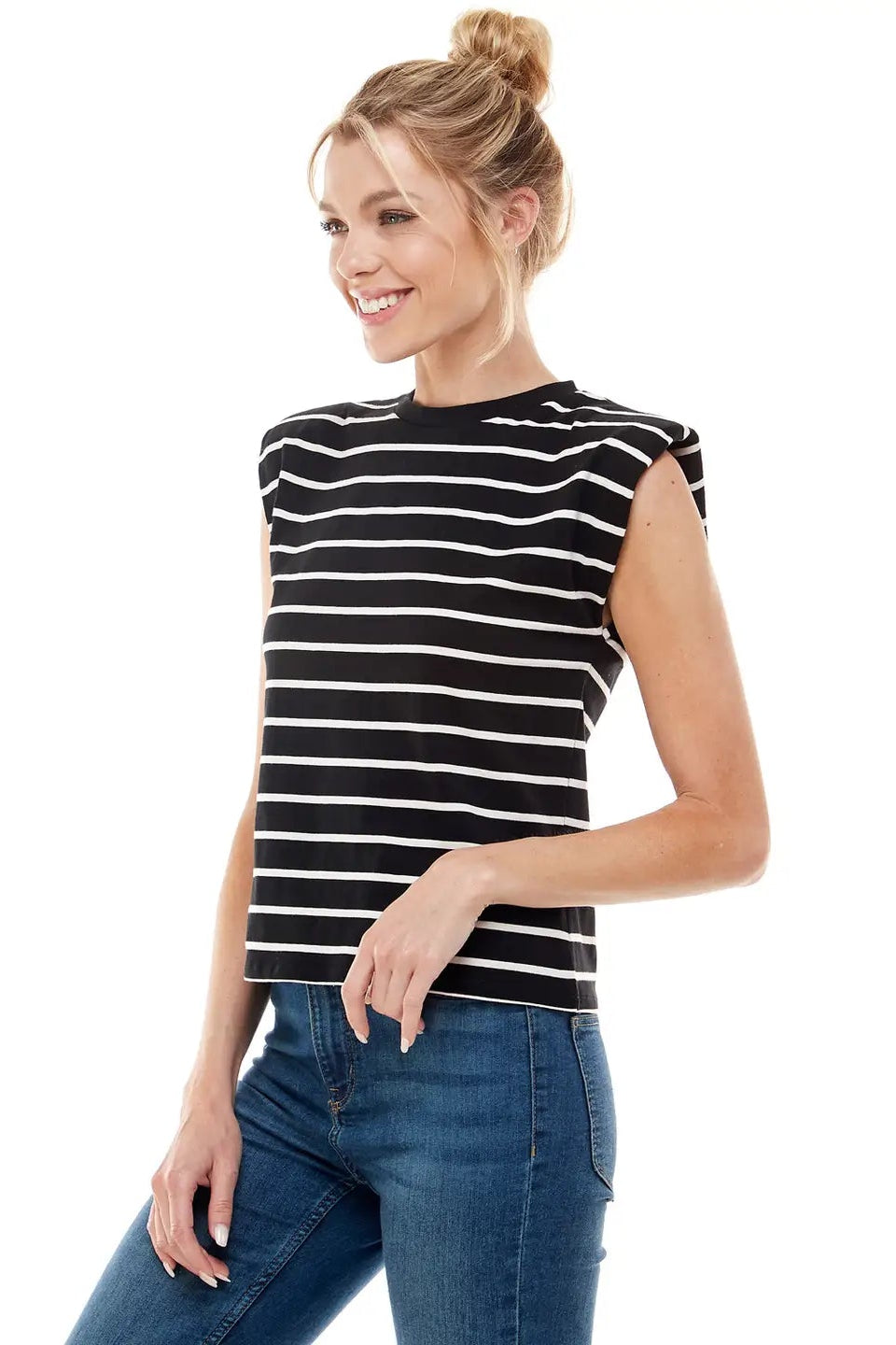 Woman wearing a black and white striped sleeveless top and blue jeans on a white background