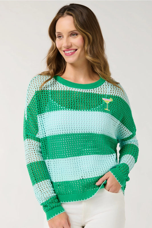 Woman wearing a green and light blue striped sweater on a white background