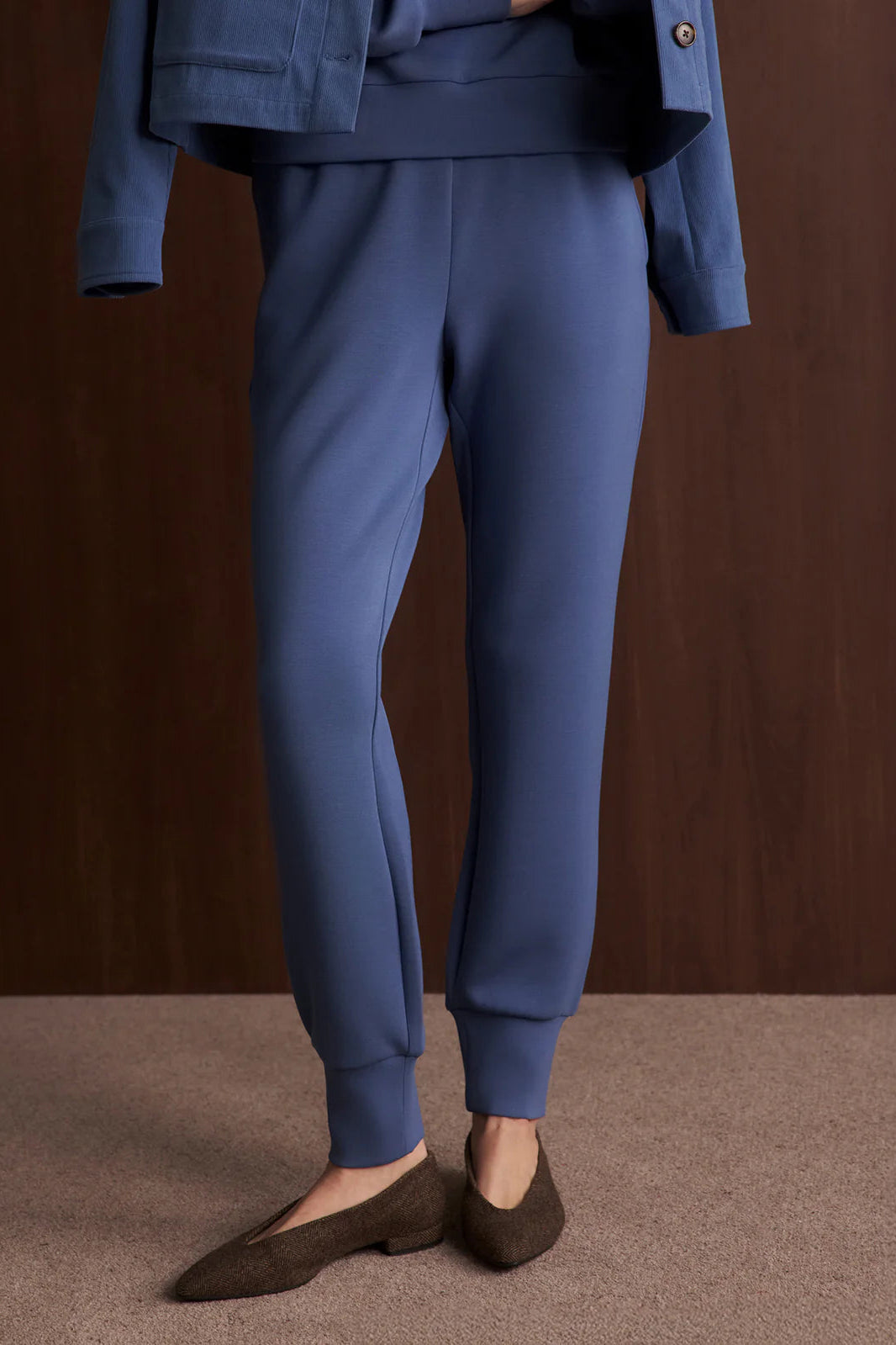 Blue pants worn by a person on a brown background