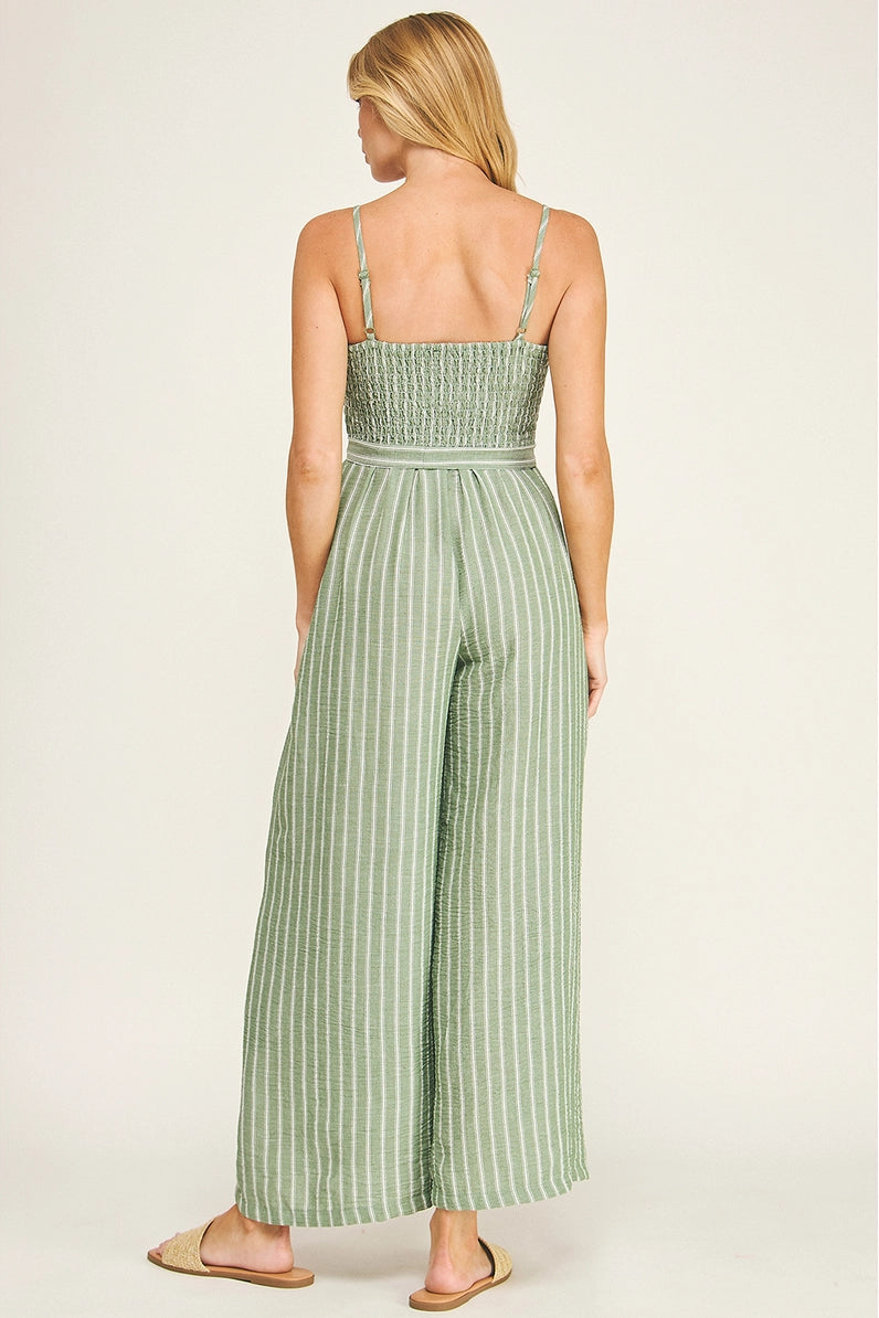 Woman wearing a green striped jumpsuit on a white background