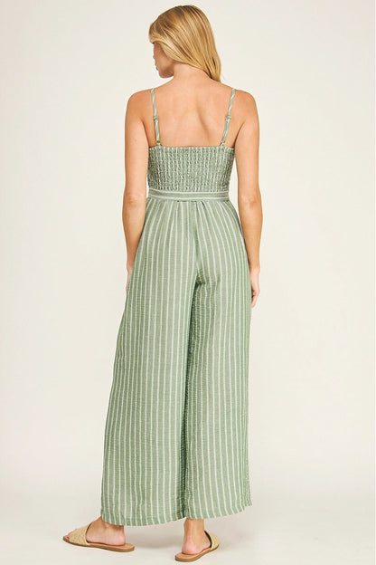 Woman wearing a green striped jumpsuit on a white background