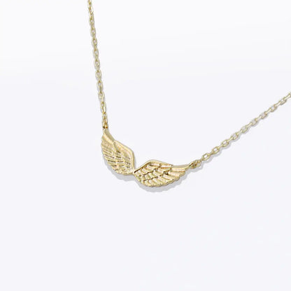 Gold wing-shaped pendant necklace on a white background