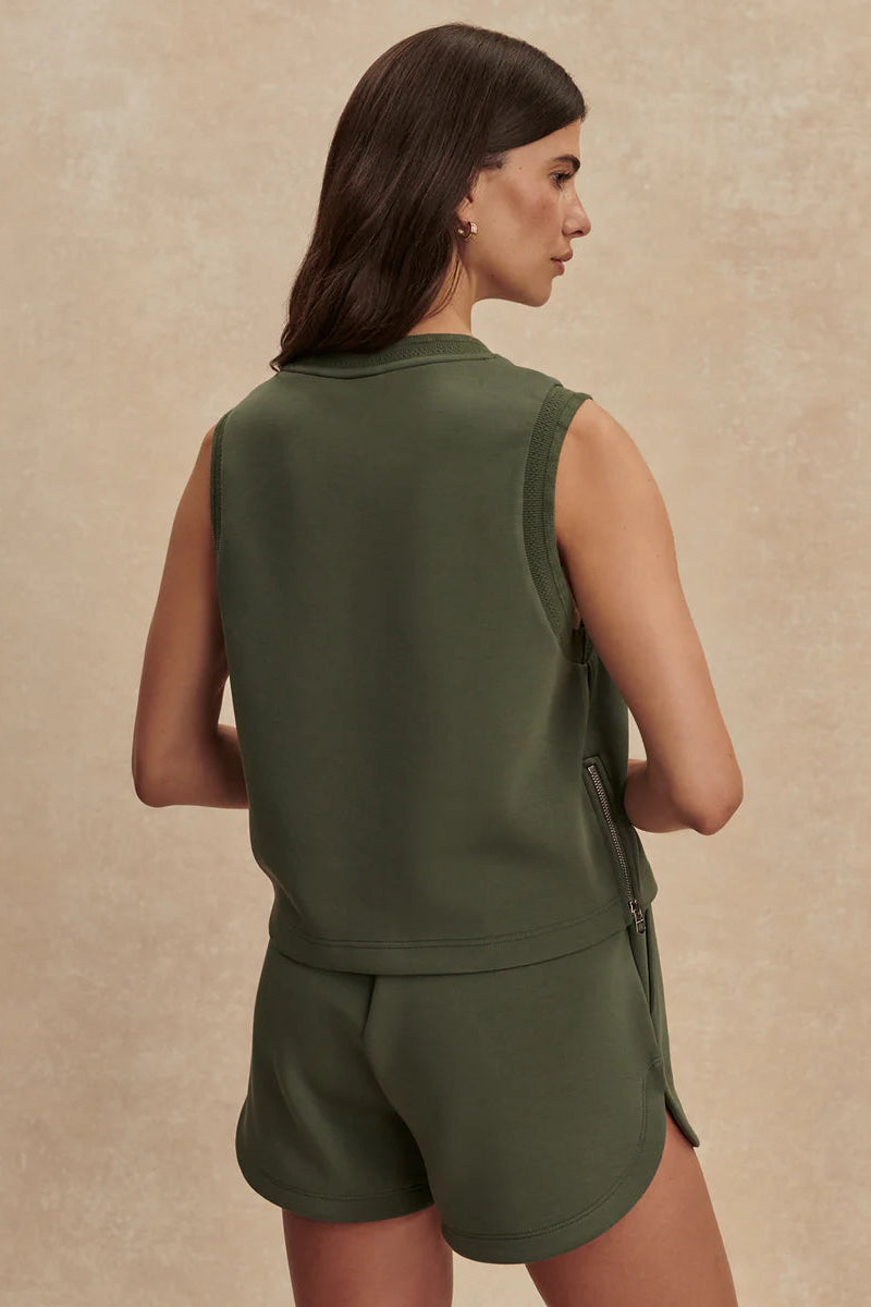 woman wearing green top and green shorts