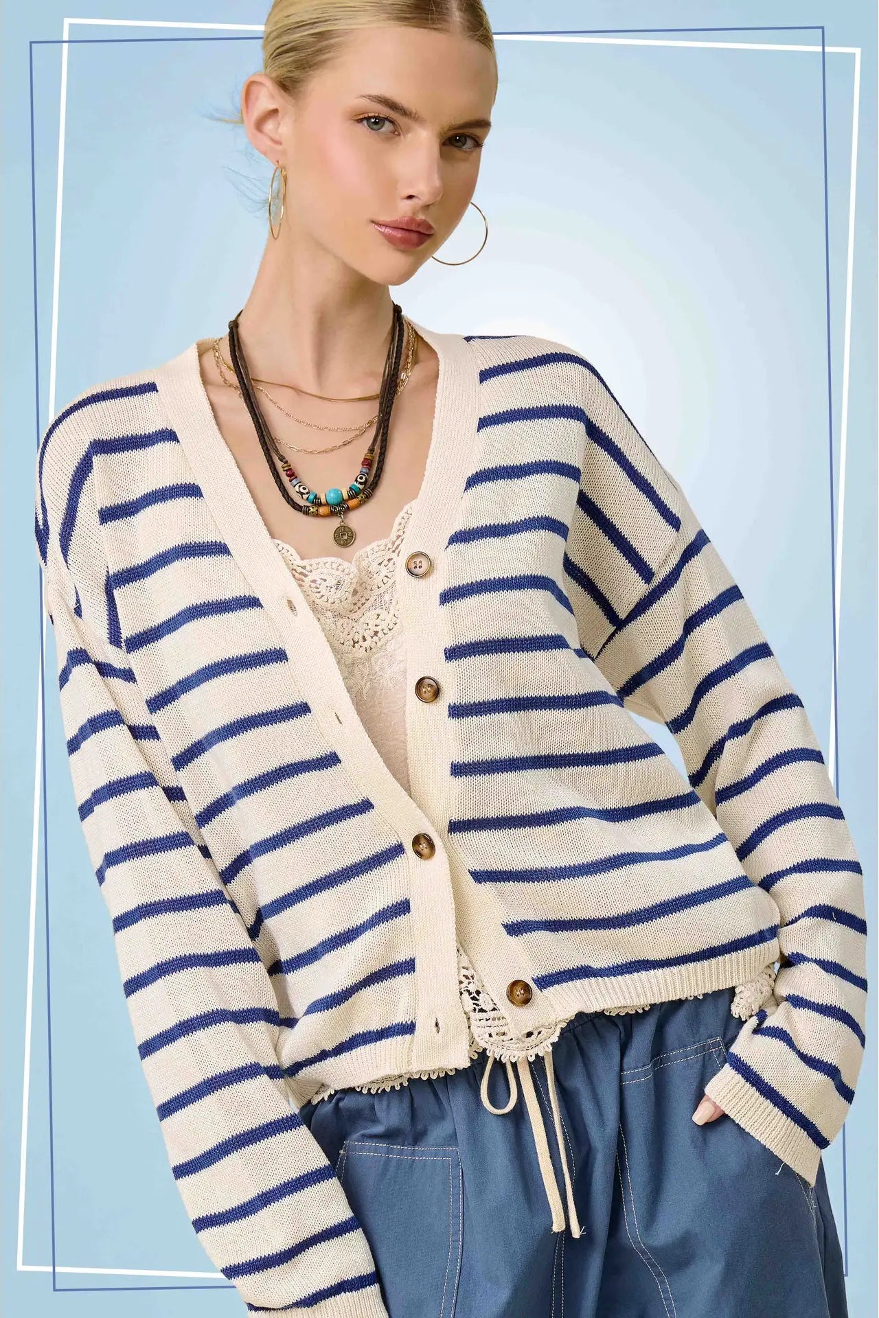 Woman wearing a striped cardigan with a blue background