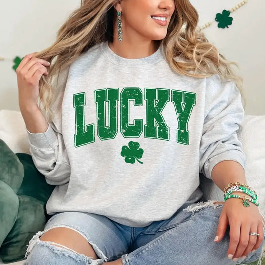 woman wearing gray sweatshirt with Lucky acoss the chest in green with clover