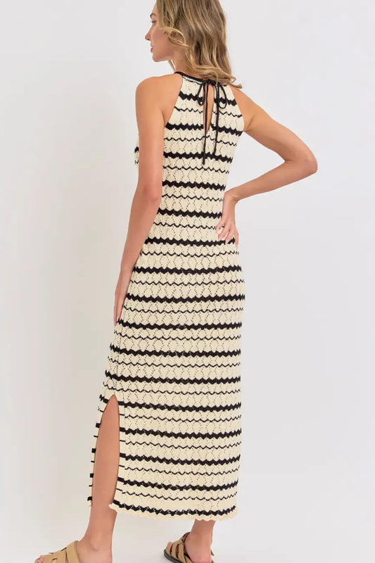 Woman wearing a black and white striped dress against a white background