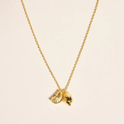 Gold necklace with a unique pendant on a beige background