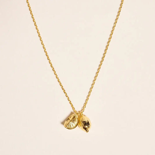 Gold necklace with a unique pendant on a beige background