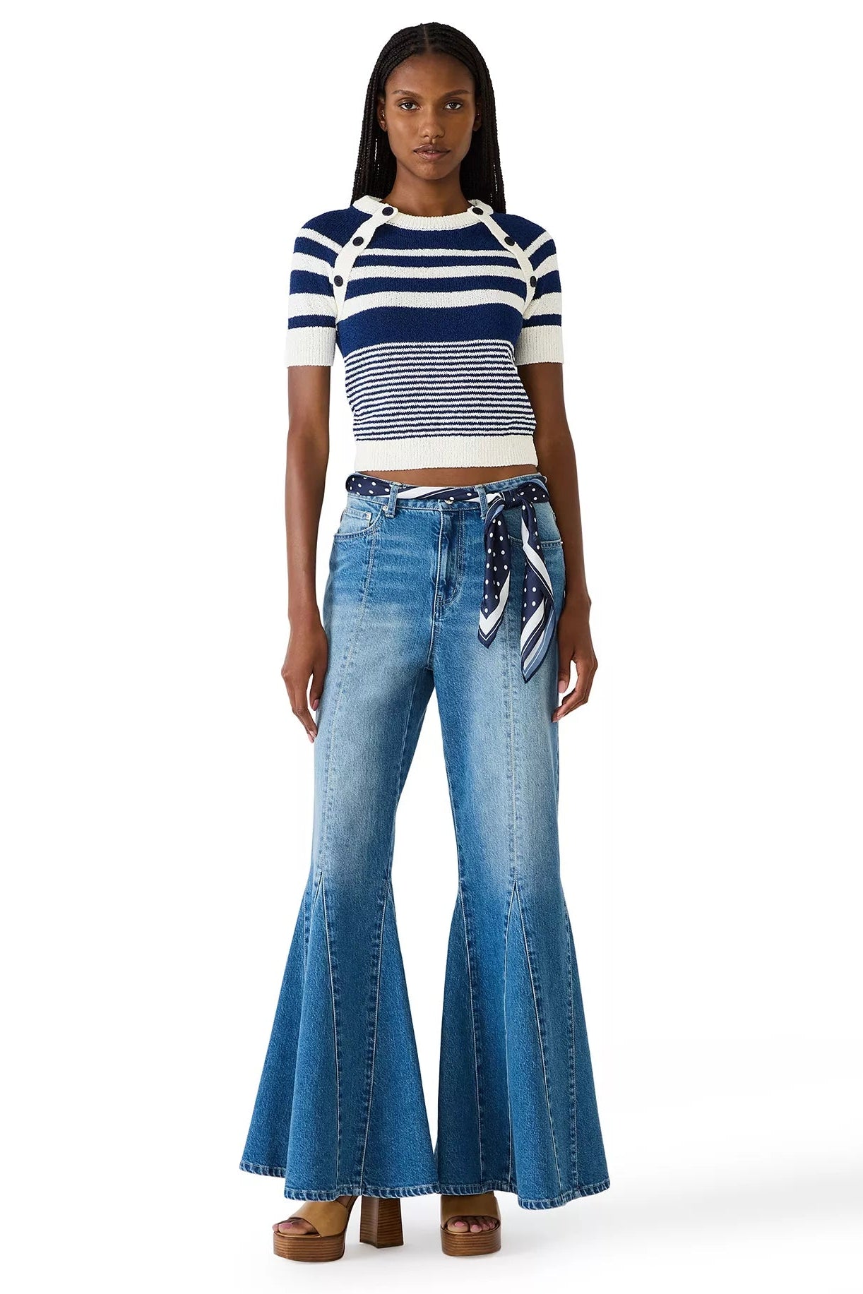 Woman wearing a striped shirt and blue jeans on a white background