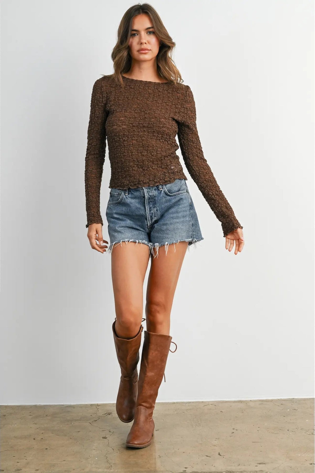 woman in textured long sleeve top and shorts and boots