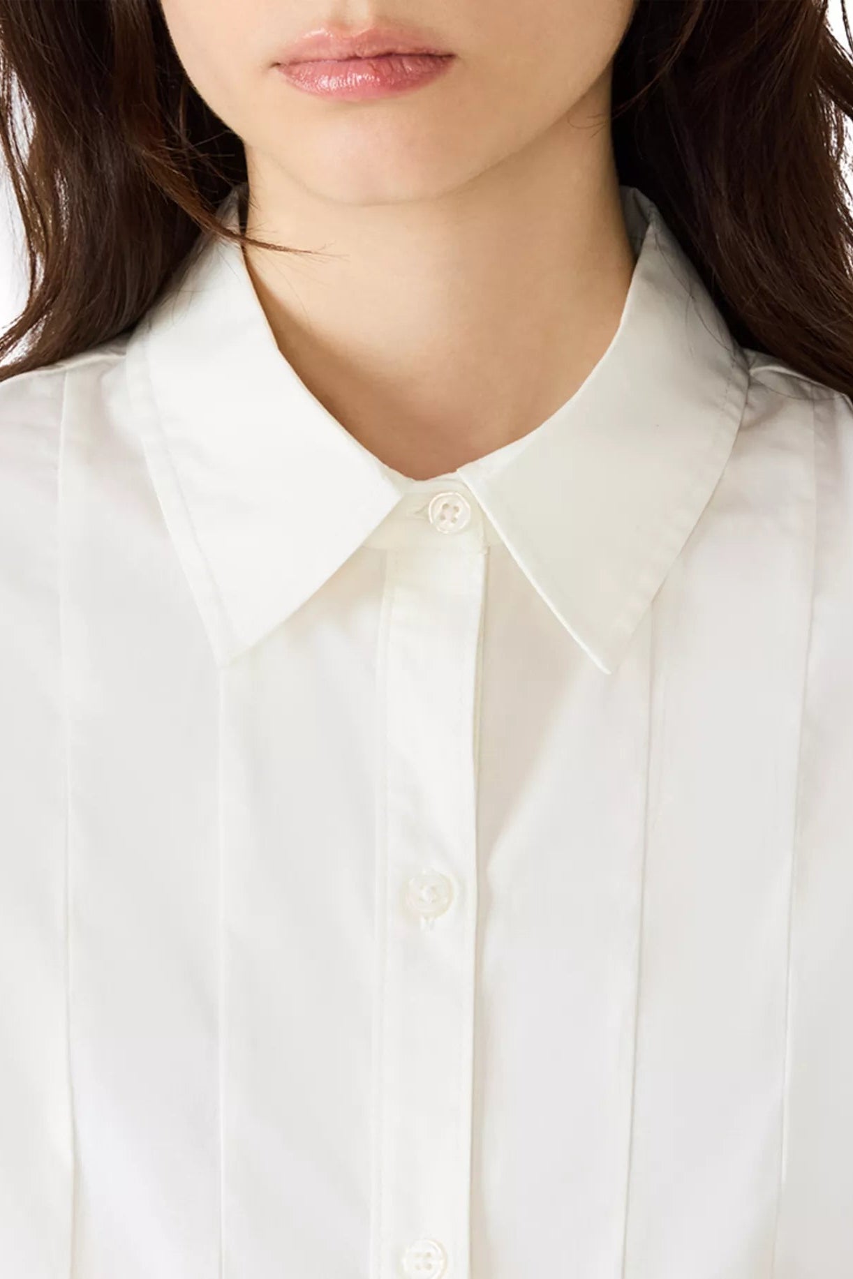 Close-up of a person wearing a white shirt with a blurred background