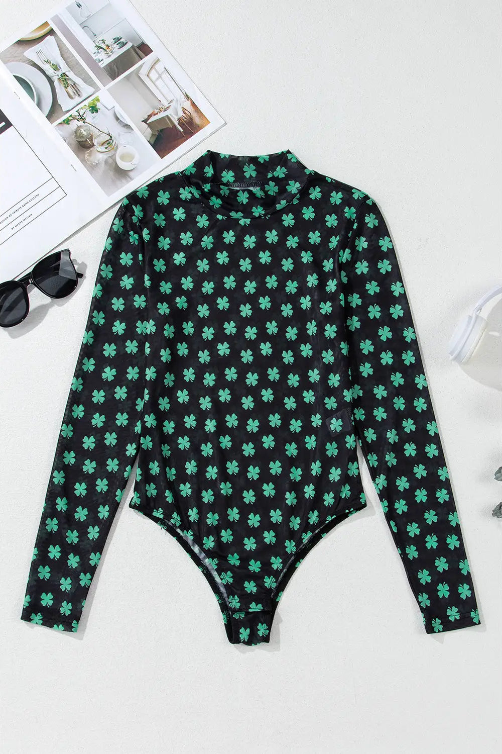 Green and black patterned long-sleeve top on a white background