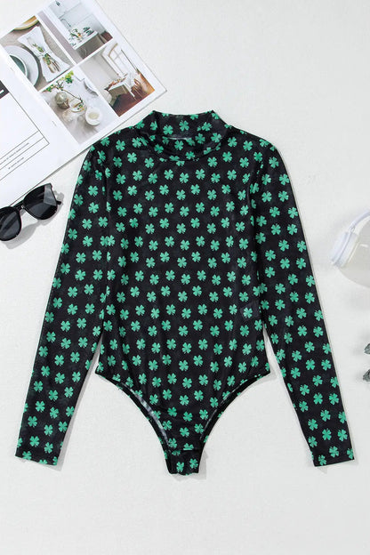 Green and black patterned long-sleeve top on a white background