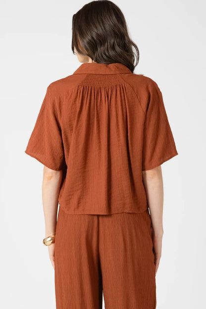 Person wearing a brown outfit on a white background