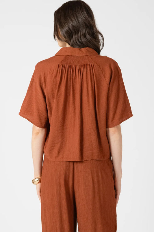 Person wearing a brown outfit on a white background