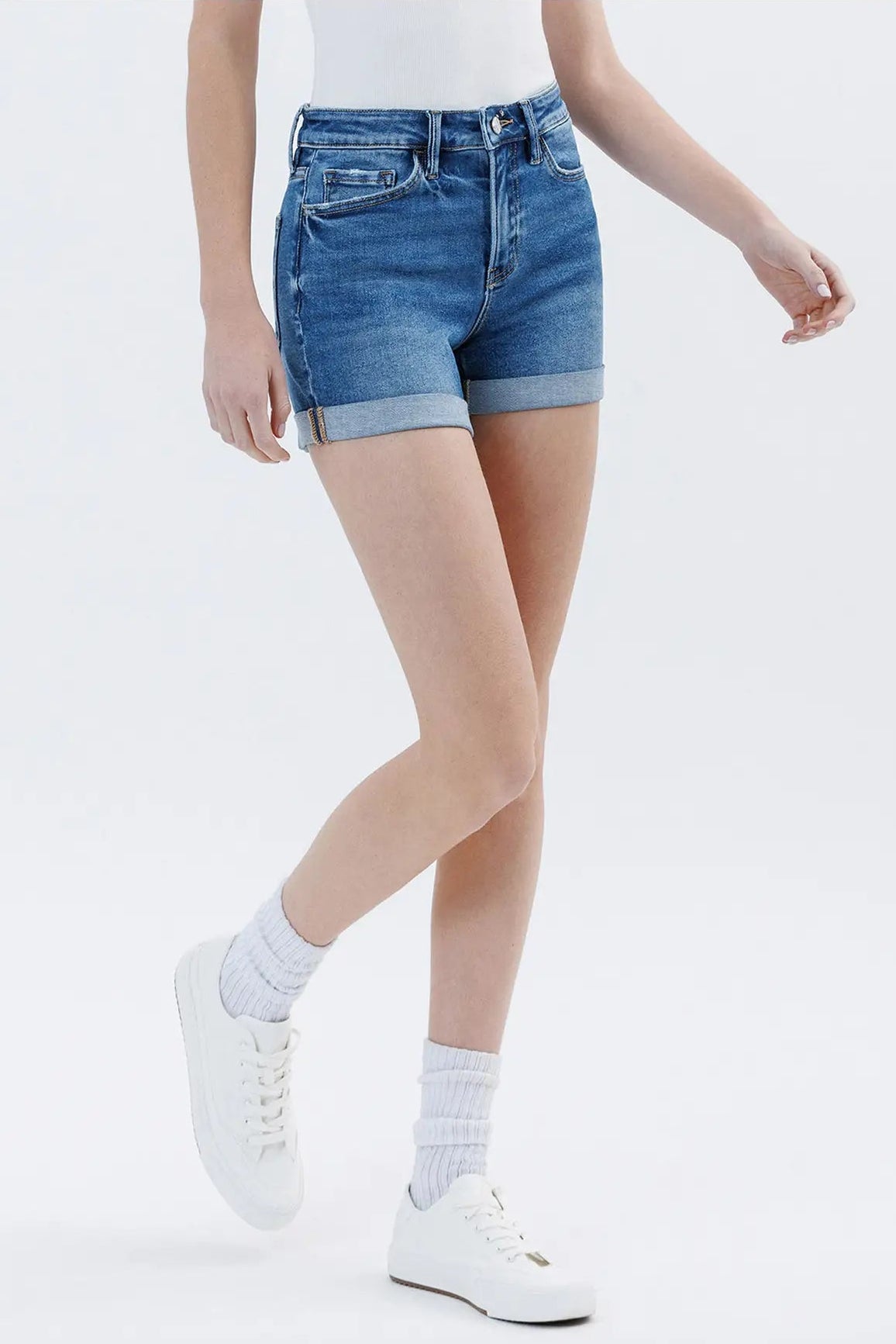 Person wearing blue denim shorts on a white background