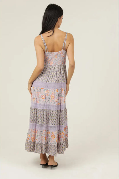 Woman wearing a floral patterned dress on a plain background