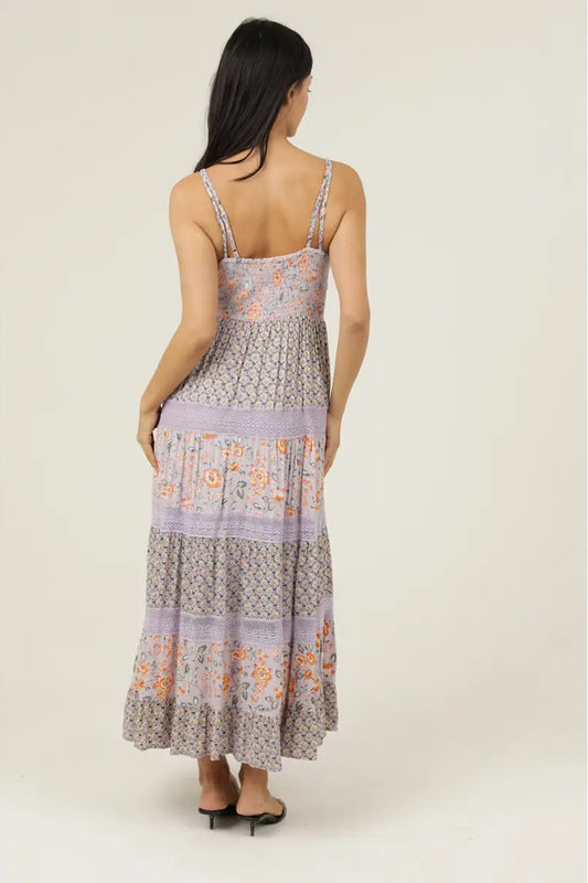 Woman wearing a floral patterned dress on a plain background
