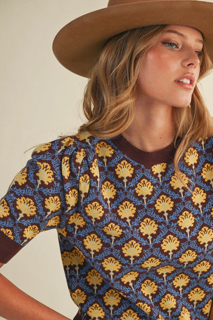 woman in short sleeve floral sweater and hat