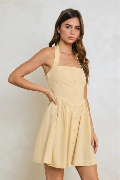 Woman wearing a yellow dress against a plain background