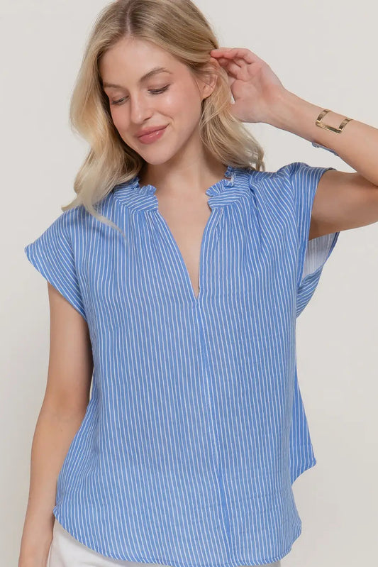 Woman wearing a blue striped shirt against a plain background