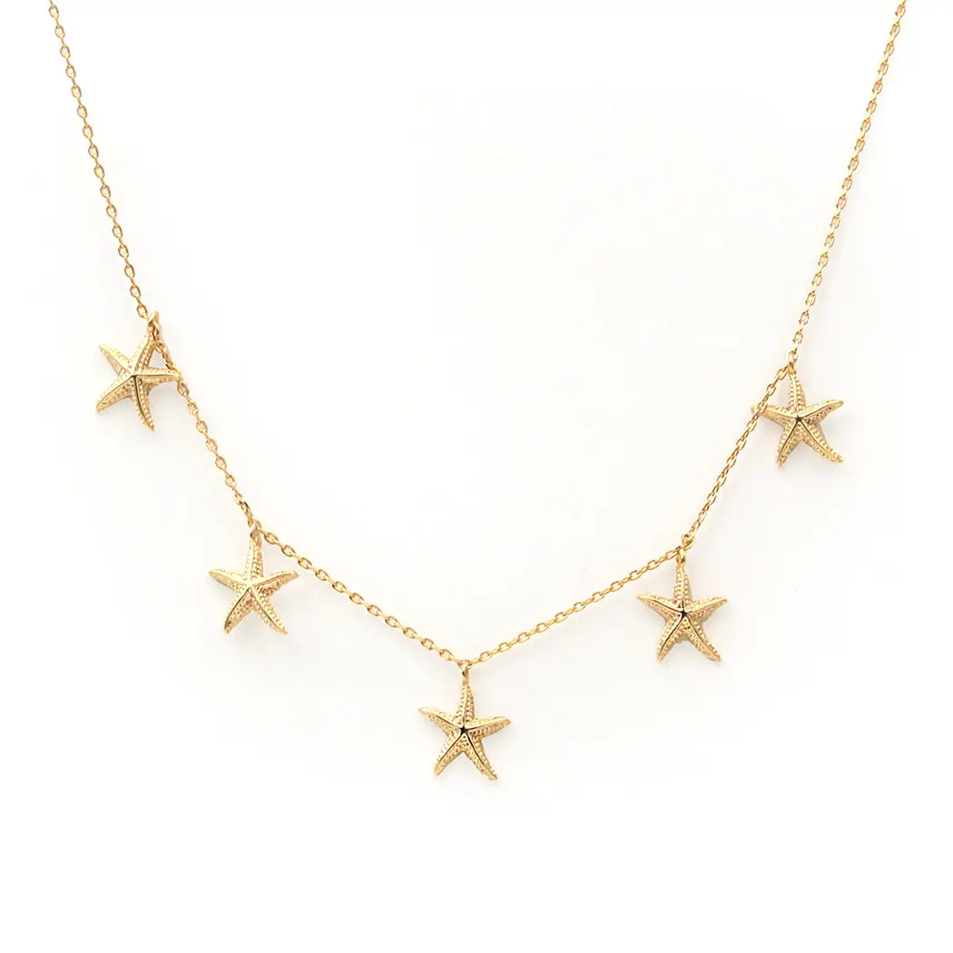 Gold starfish necklace on a white background