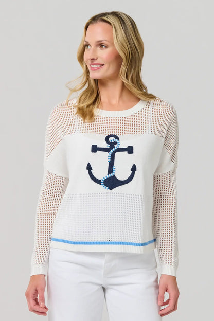 Woman wearing a white sweater with an anchor design on a gray background
