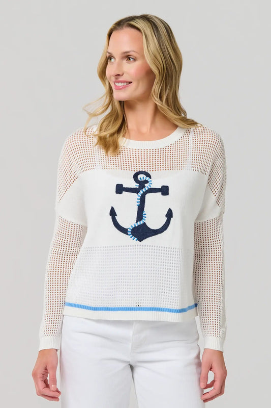 Woman wearing a white sweater with an anchor design on a gray background