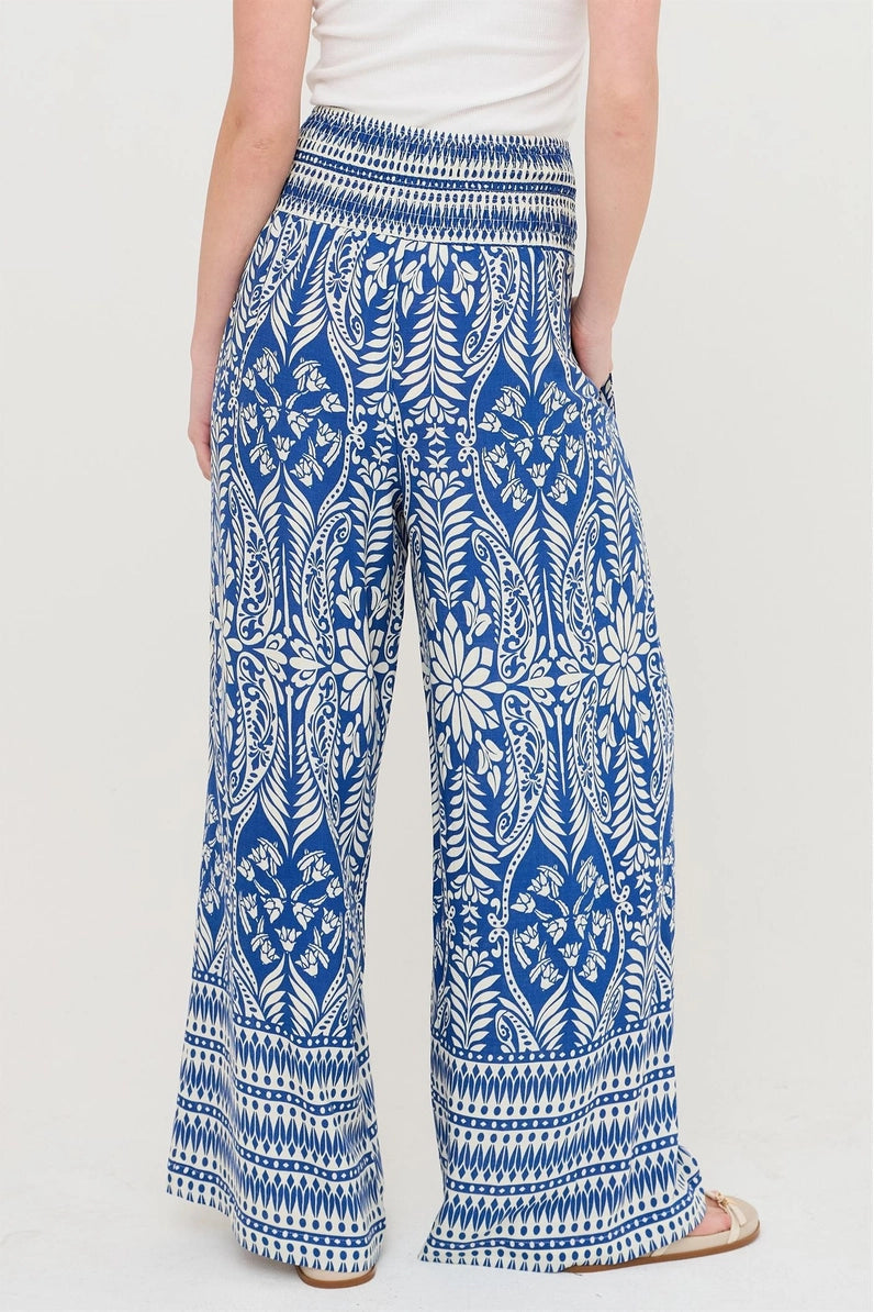 Blue and white patterned pants worn by a person on a white background
