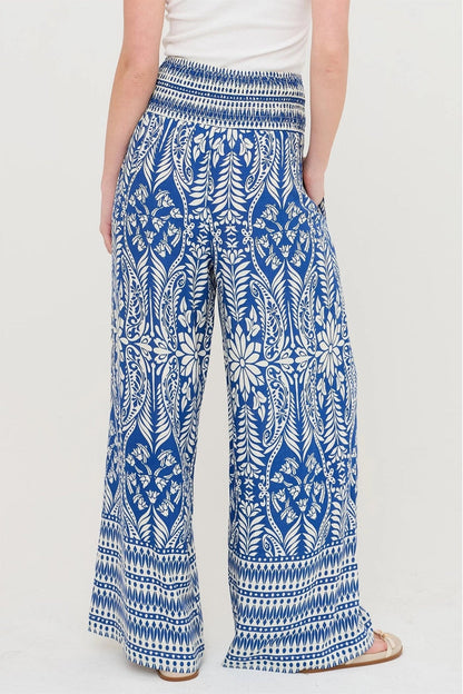 Blue and white patterned pants worn by a person on a white background