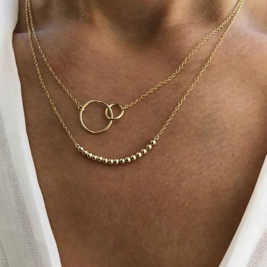 Gold necklace with interlocking rings on a person's neck