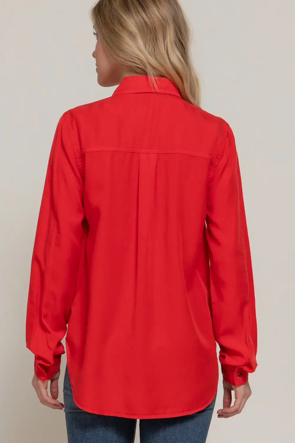 Person wearing a red shirt with a neutral background