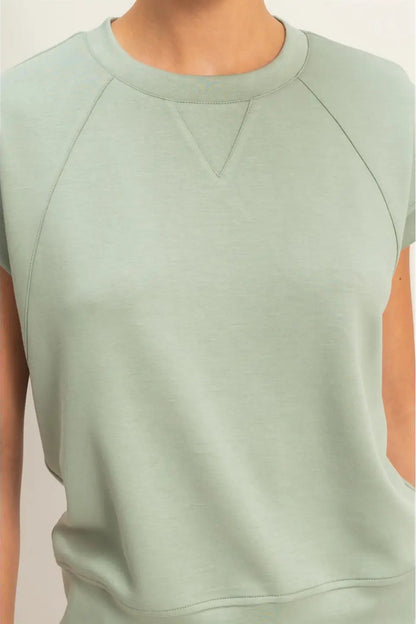 Light green sleeveless top worn by a person on a plain background
