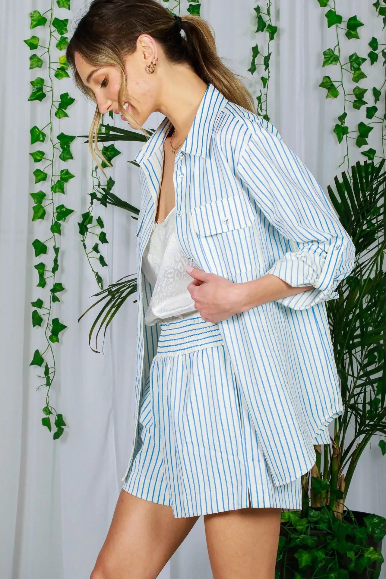 woman wearing blue and white button up shirt and shorts