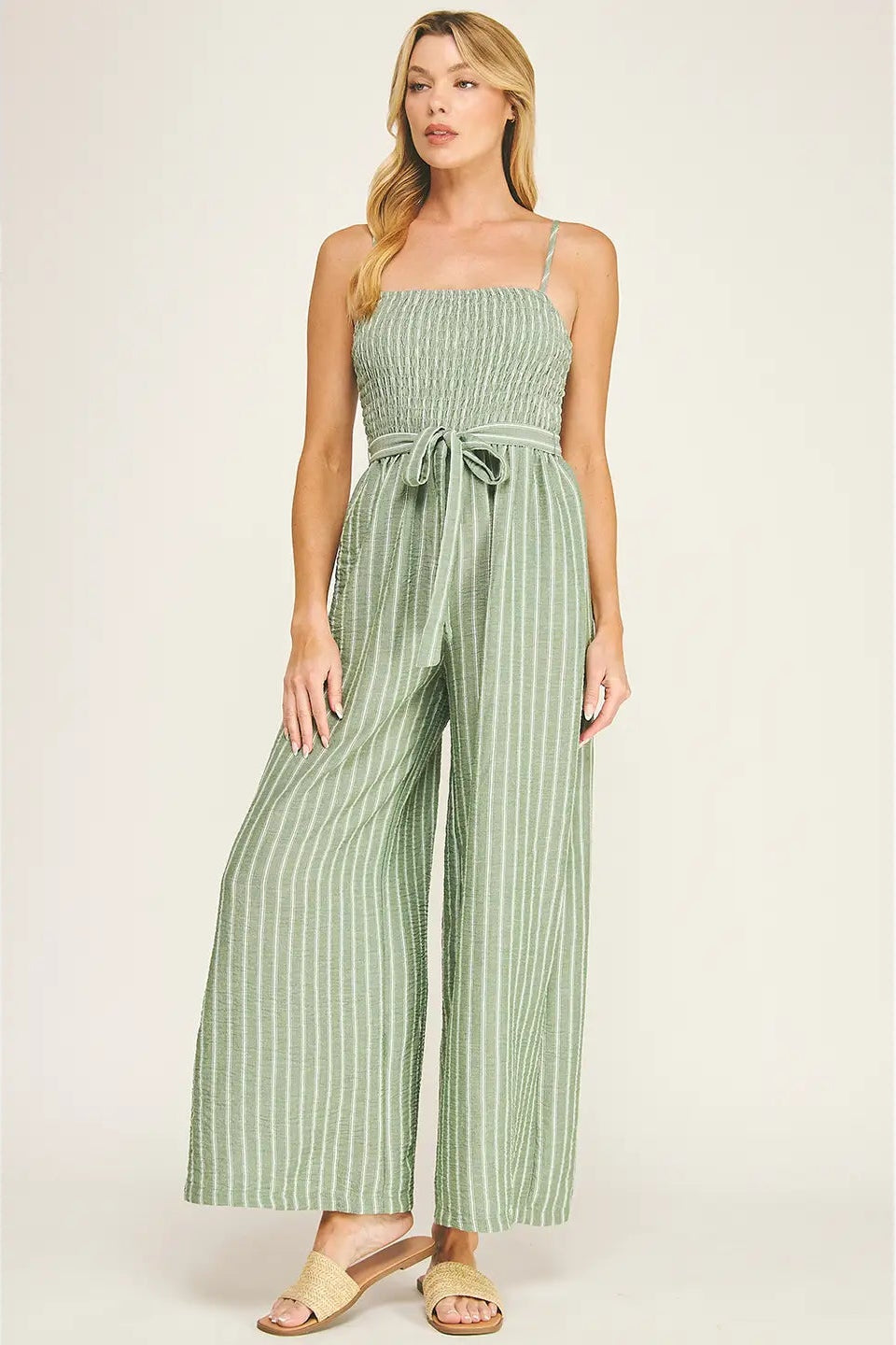 Woman wearing a green striped jumpsuit on a white background