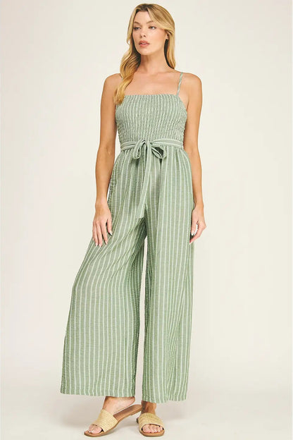 Woman wearing a green striped jumpsuit on a white background