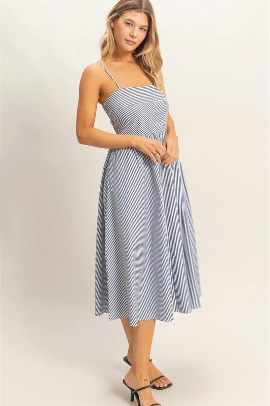 Woman wearing a blue and white striped dress on a plain background