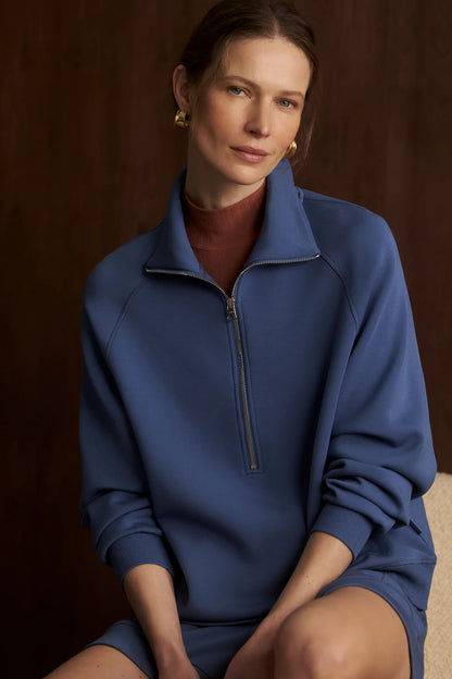 Woman wearing a blue pullover against a brown background