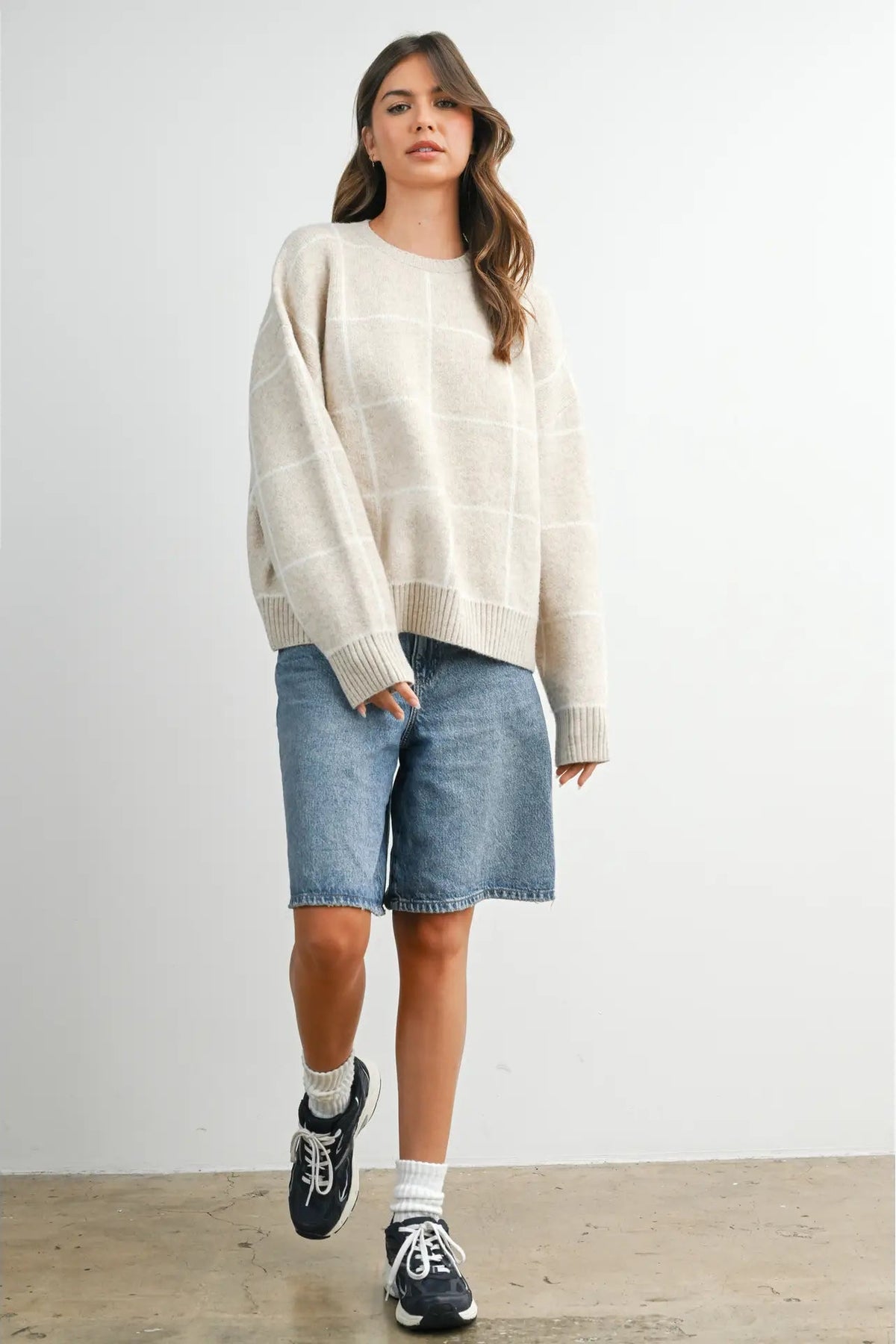 woman in check sweater and shorts