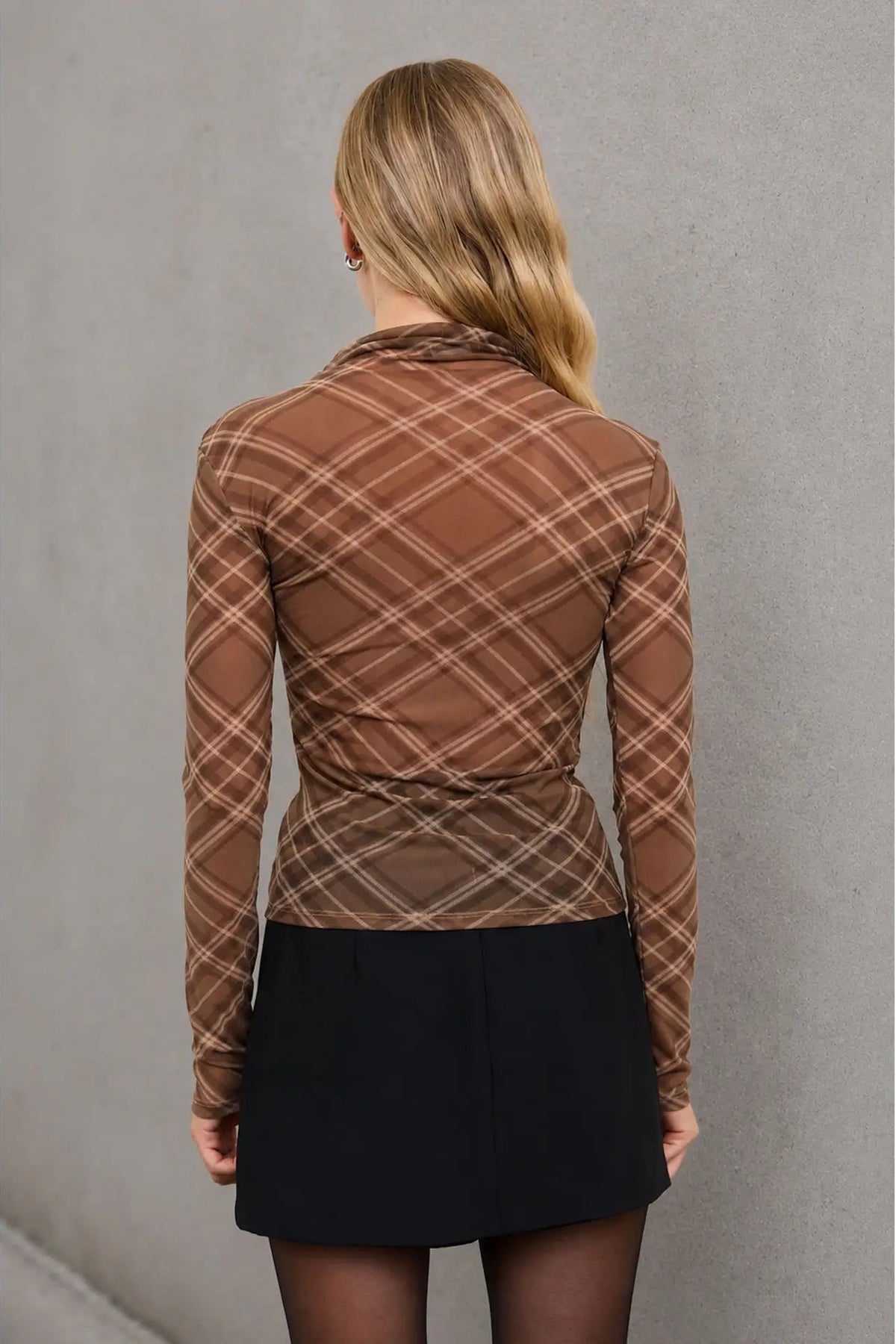 back view of woman in plaid mesh top and skirt 