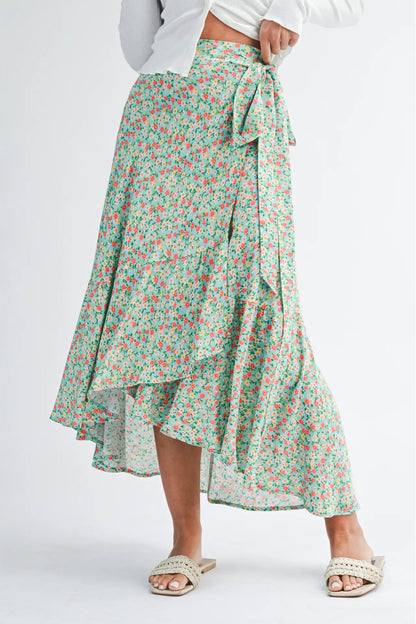 Green floral skirt worn by a person on a white background