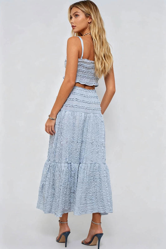 Woman wearing a light blue ruffled dress against a white background