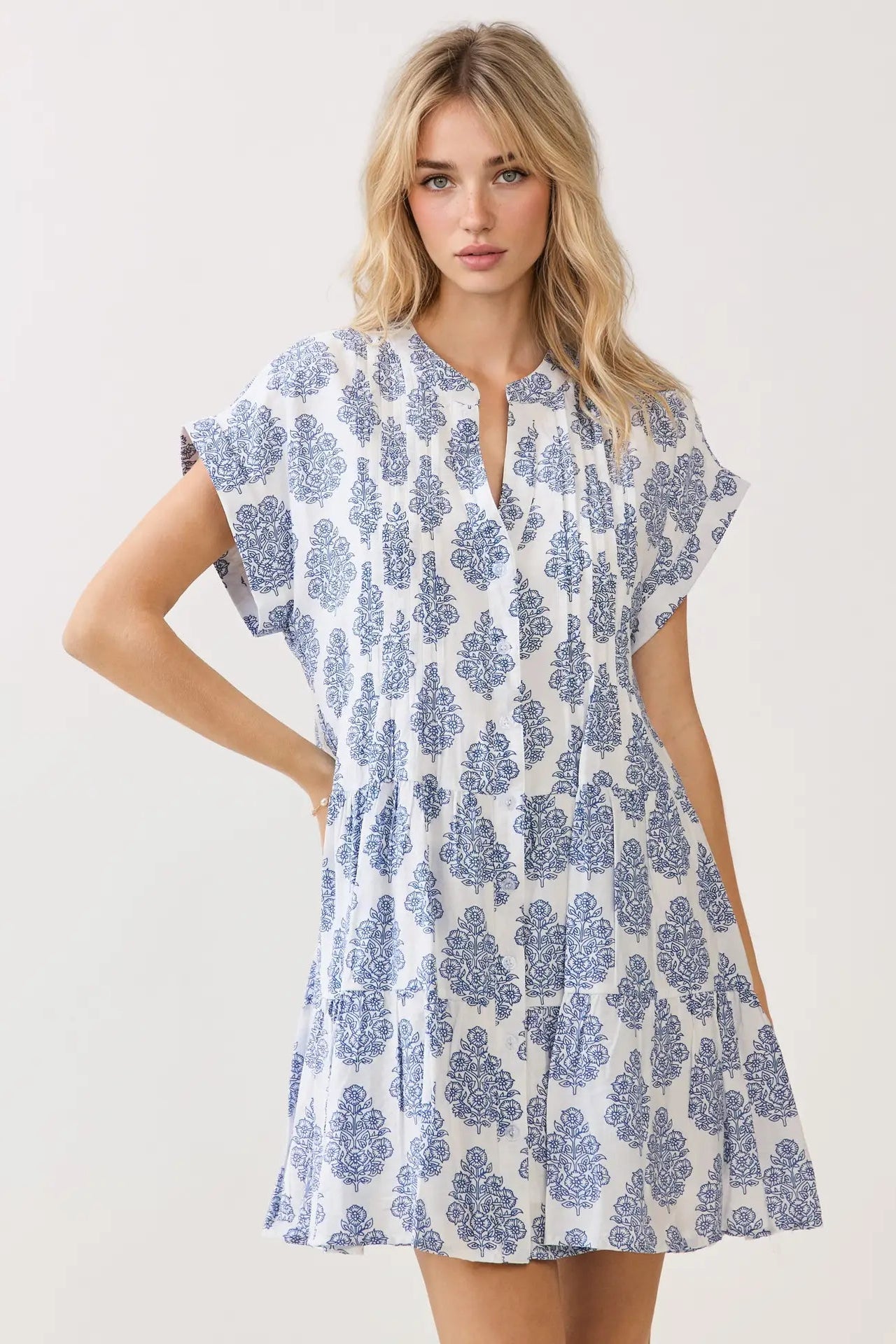 Woman wearing a blue and white patterned dress on a plain background