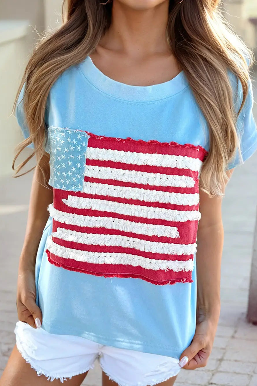 Light blue t-shirt with American flag design worn by a person.